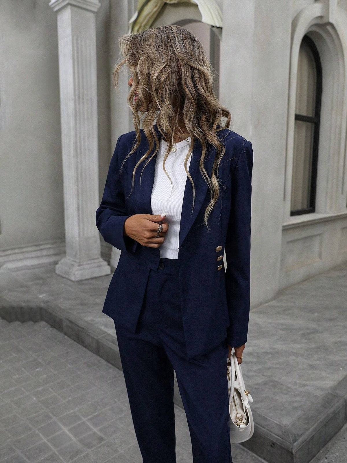 Completo tailleur da donna in stile decostruttivo con bottoni dorati